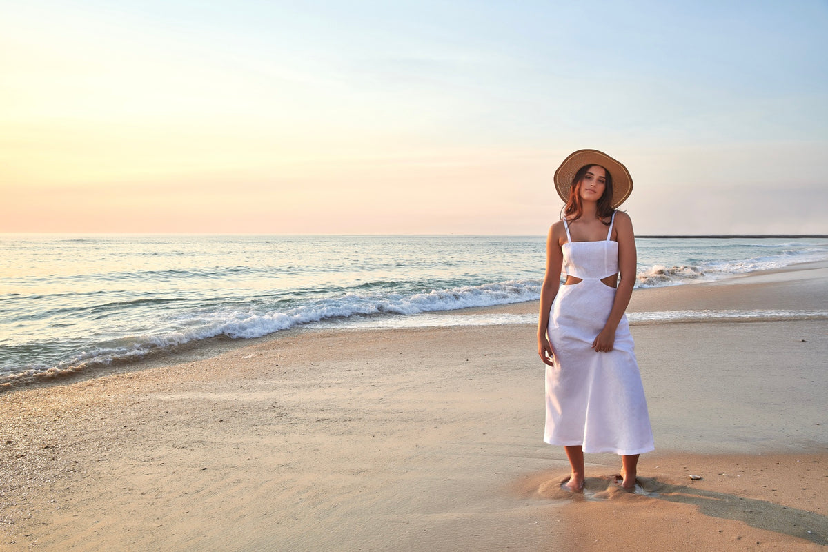 Femme portant une tenue en lin blanc Atelier Coquelicot sur une plage