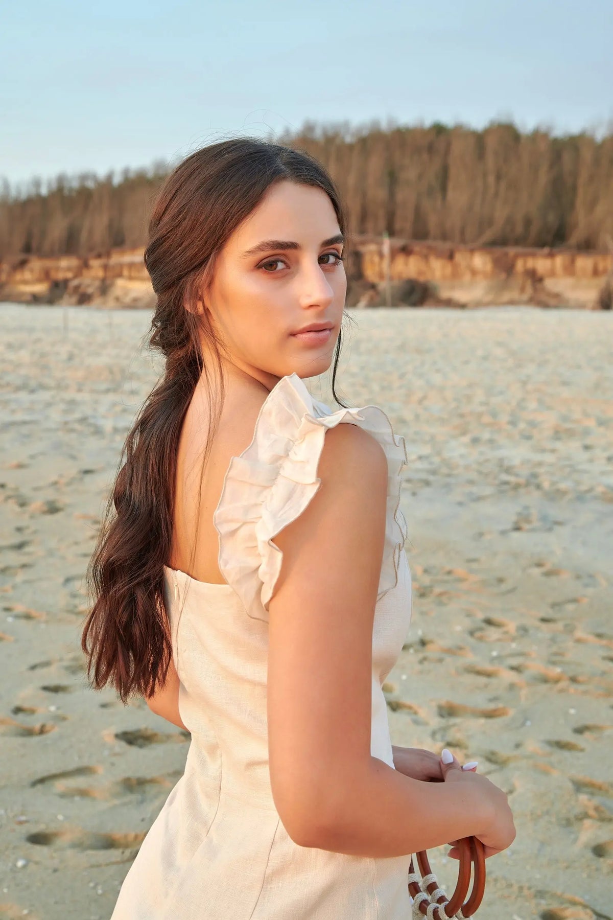 Robe Alma beige en lin portée de trois-quarts dos, avec détail des volants sur les épaules.