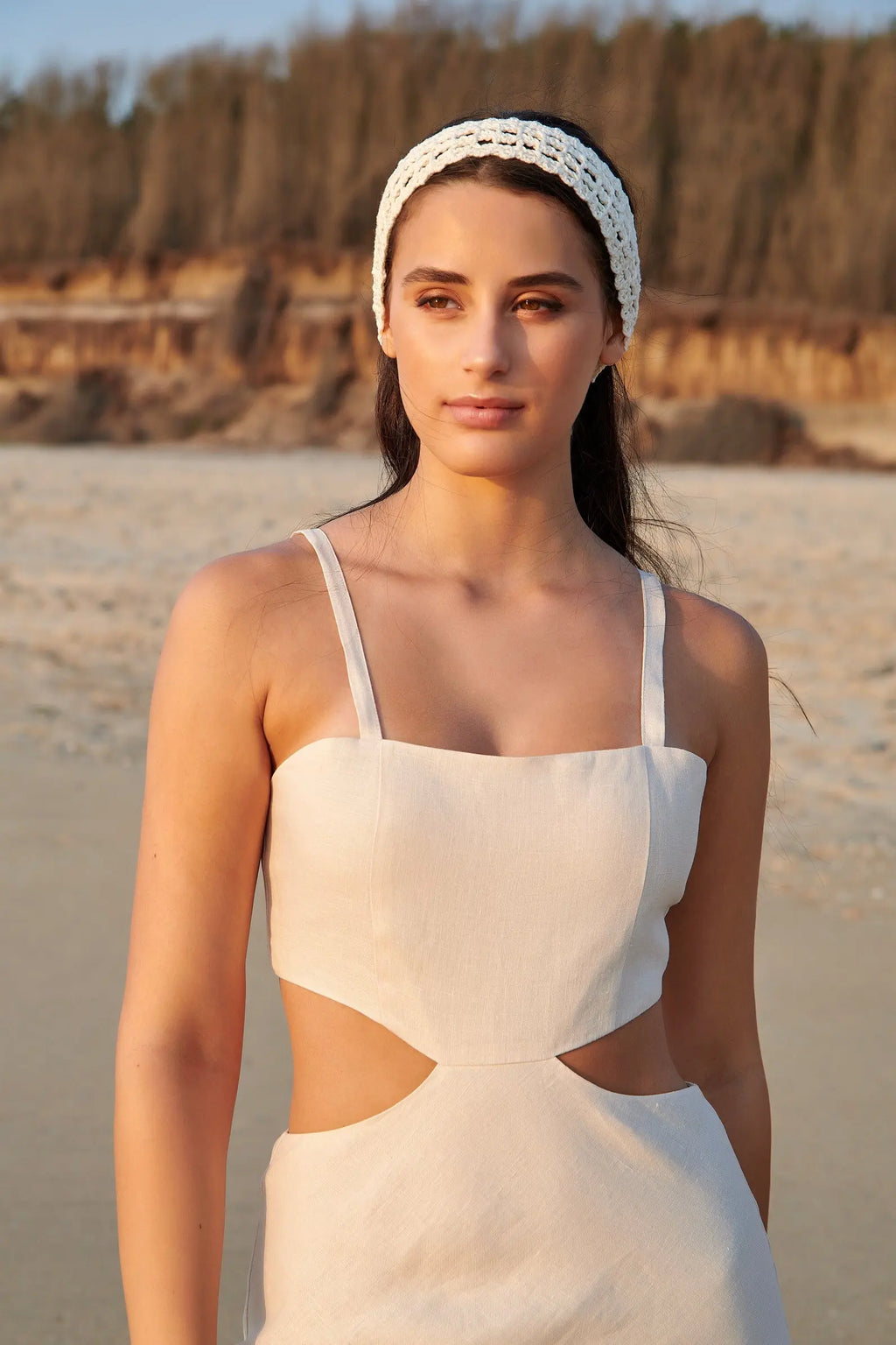 Vue rapprochée de la robe Maya beige en lin naturel, mettant en valeur son encolure droite et ses découpes à la taille.